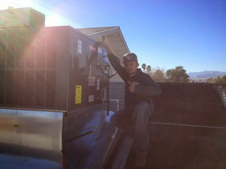 HVAC technician performing AC Tune-Up on a rooftop unit in Seguin